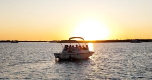 Lancha elétrica navegando pela deslumbrante paisagem da Ria Formosa ao pôr do sol.